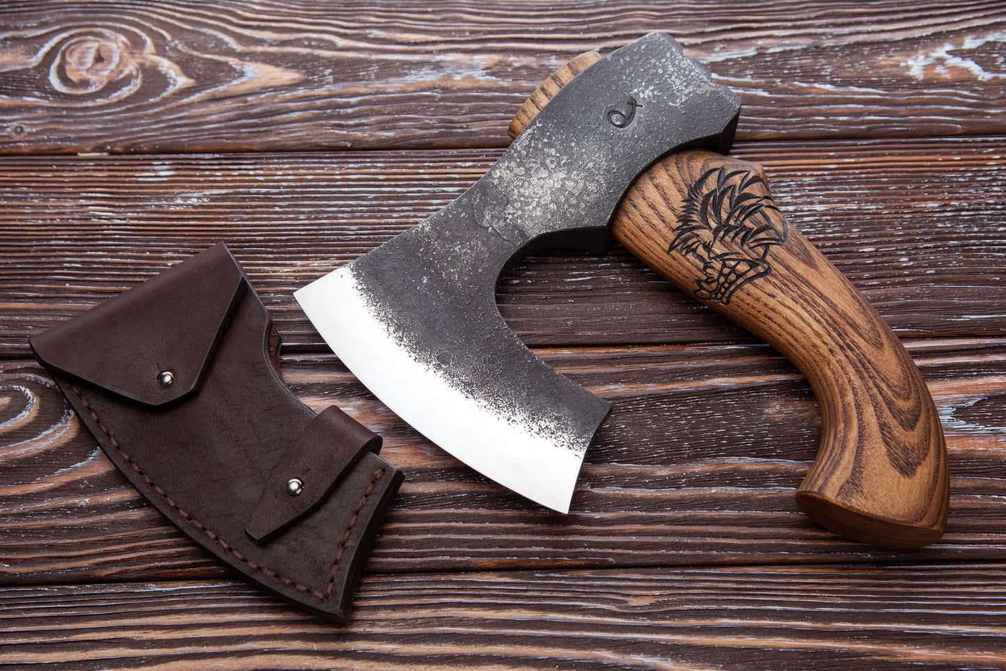 Wooden-handled axe with leather sheath on a wooden surface