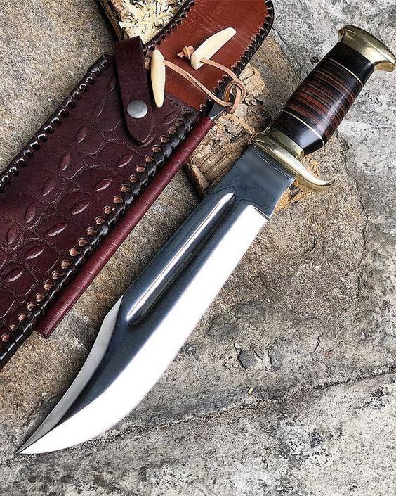Knife with a wooden handle and leather sheath on a stone surface