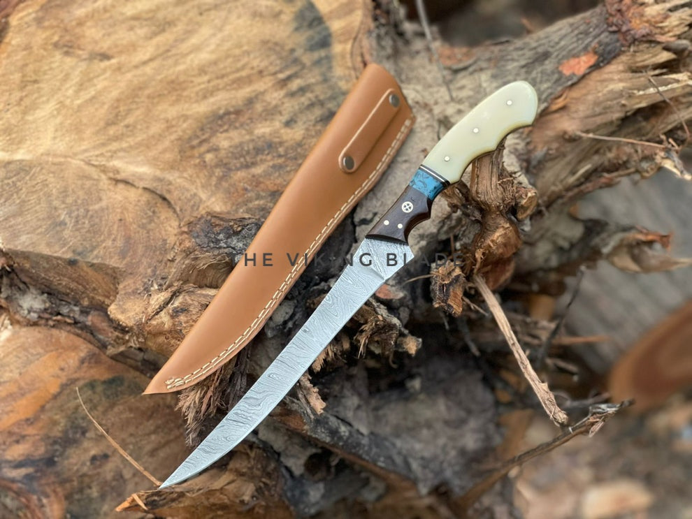Knife with leather sheath on a wooden surface, featuring the brand 'The Vagabond'.