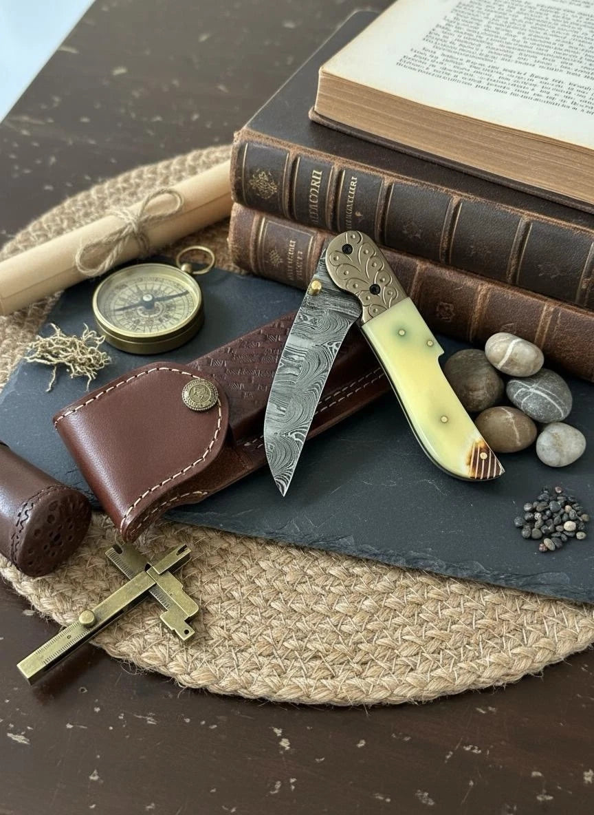 Vintage-style knife, compass, and books on a textured surface