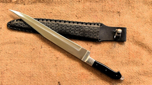 Knife with a black handle and sheath on a textured brown surface