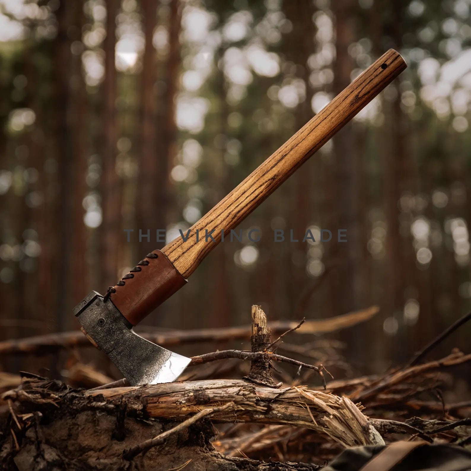 Wooden-handled axe on a log with a forest background