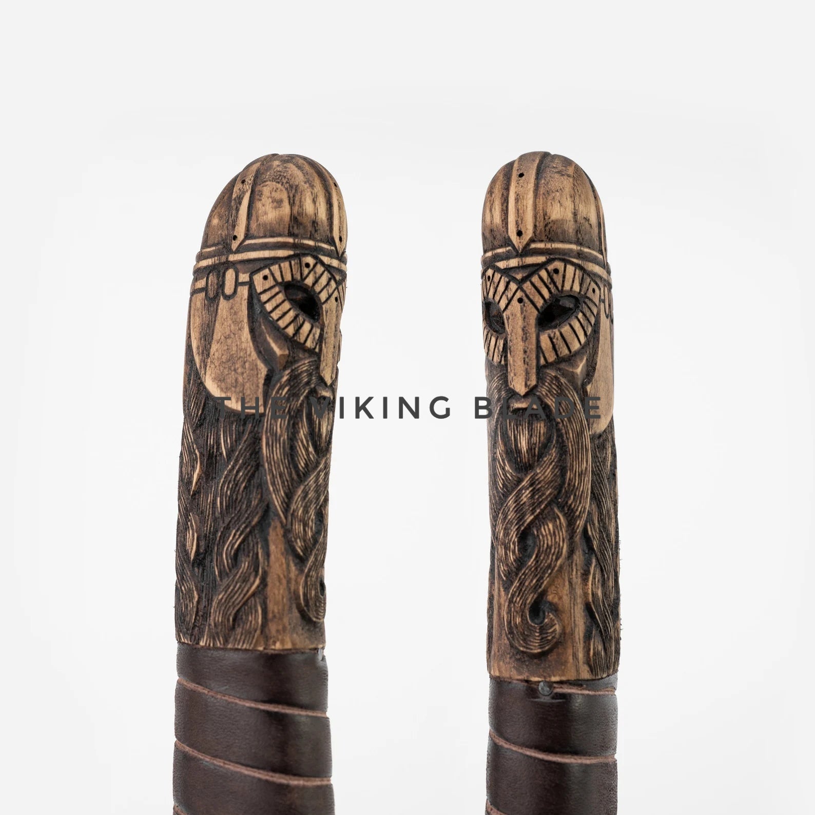 Two wooden Viking-style handles with intricate carvings on a white background.