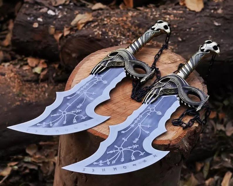 Two replica swords with intricate detailing, placed on a wooden stump, with a background of leaves and wood.