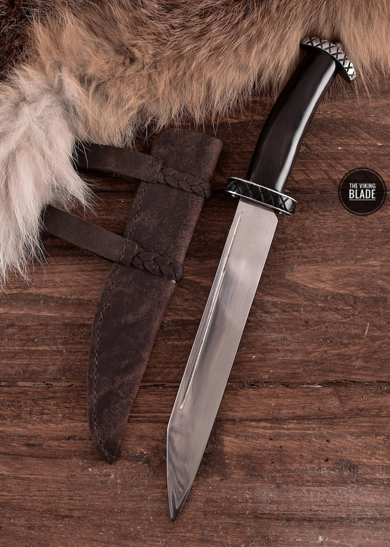 This Viking Seax Knife is a hand forged blade inspired by traditional Viking design, built for strength and durability. With a total length of 36 cm and a broad 22.5 cm blade, this knife is ideal for outdoor tasks, historical collectors, and Viking enthusiasts.