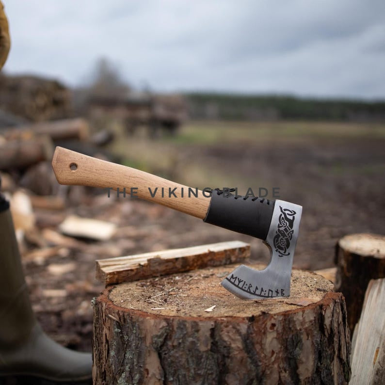 Wooden-handled axe with metal blade on a wooden stump in a forest setting