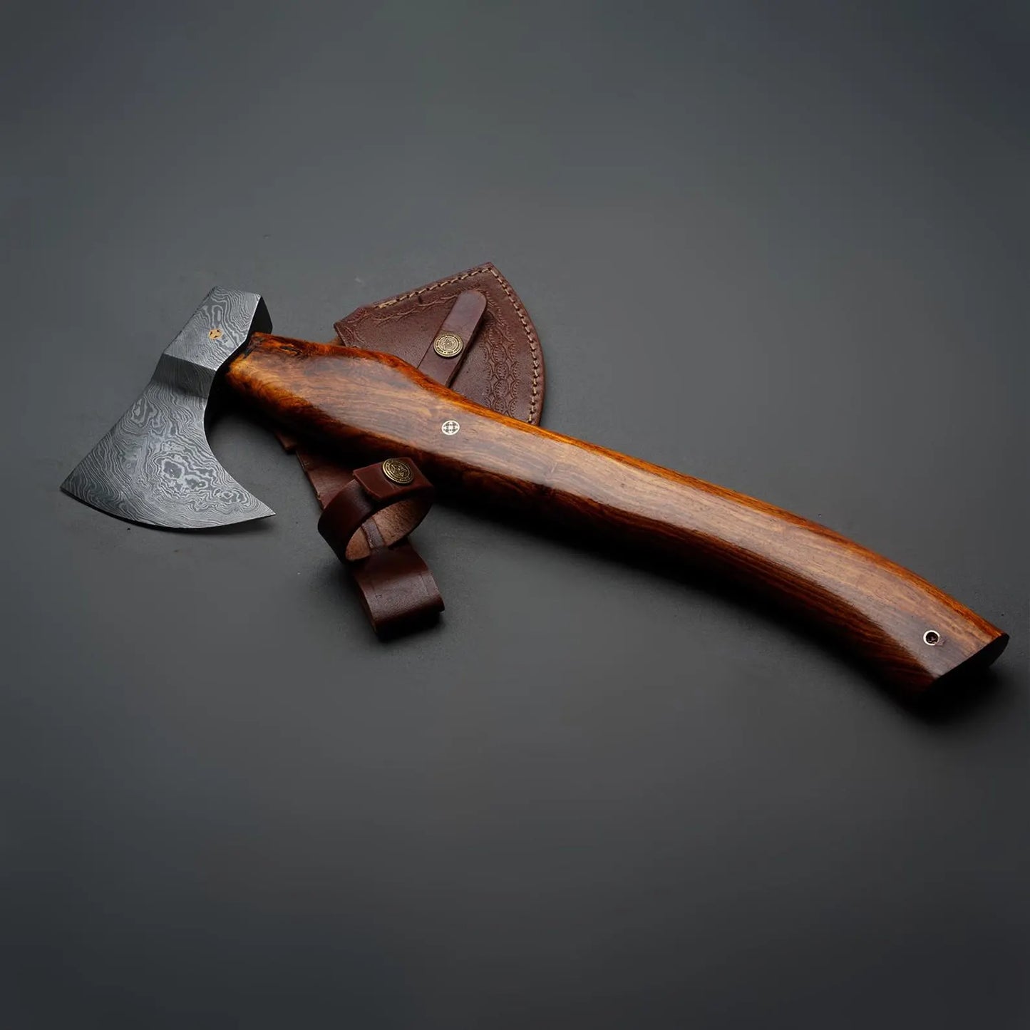 Wooden-handled axe with leather sheath on a dark gray background