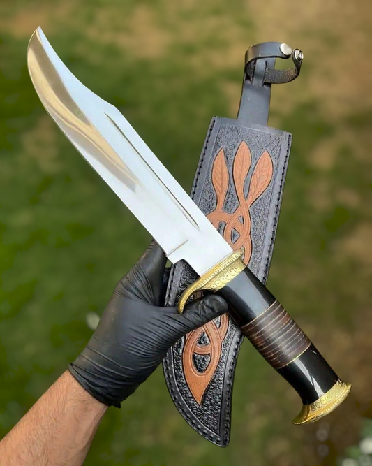 Hand holding a dagger with a decorative sheath against a blurred green background