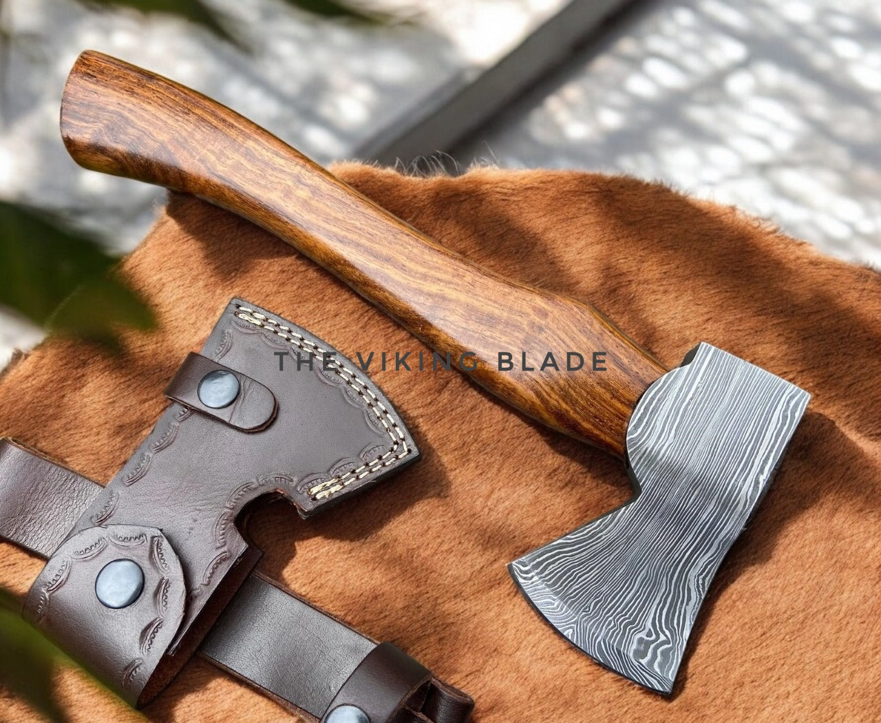 Axes with wooden handles and leather sheaths on a brown surface