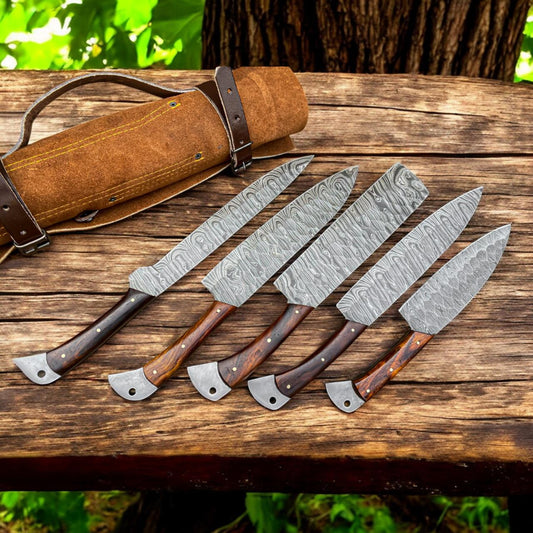 A set of custom handmade Damascus steel chef knives with leather roll kit. The knives have a distinctive layered pattern on the blade and are equipped with wooden handles and metal bolsters.