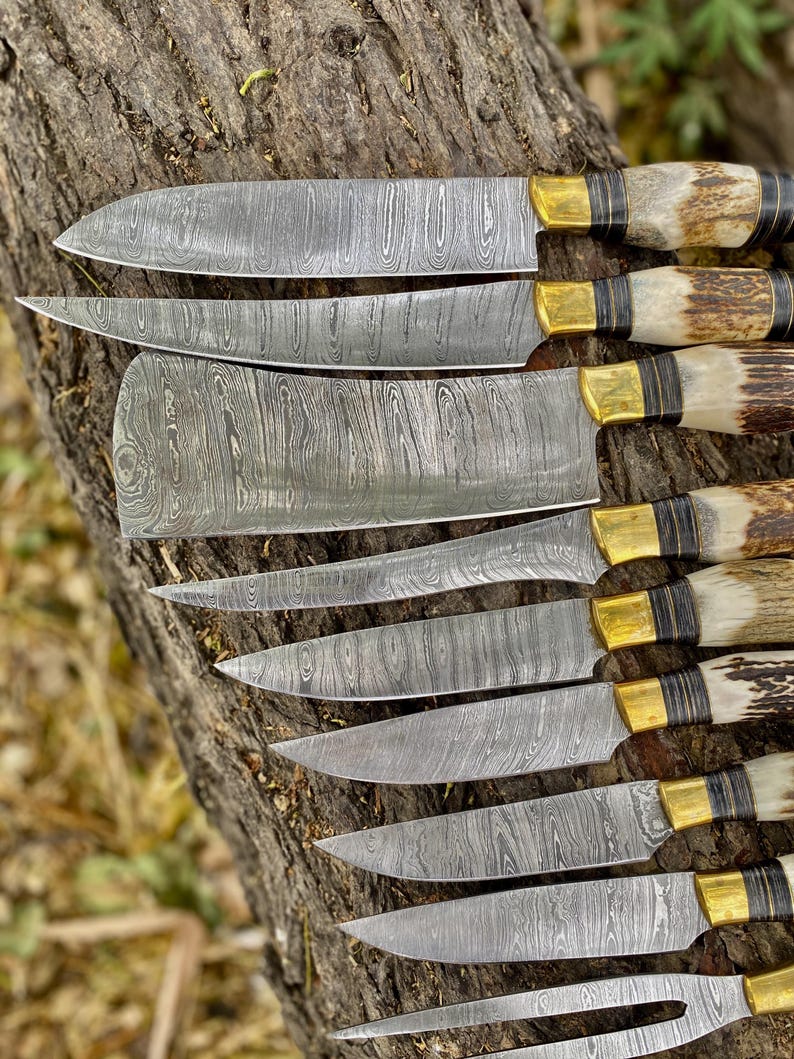 Set of Damascus steel knives with wooden handles on a wooden surface
