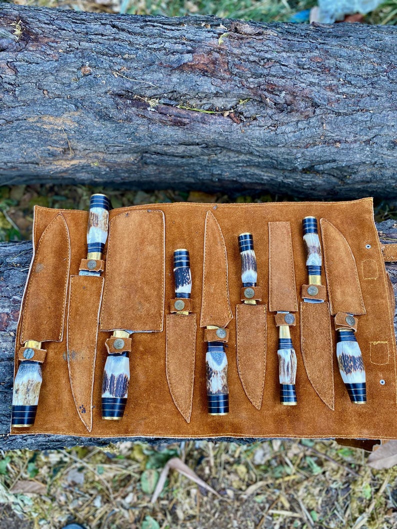 Set of knives in a leather sheath on a natural background