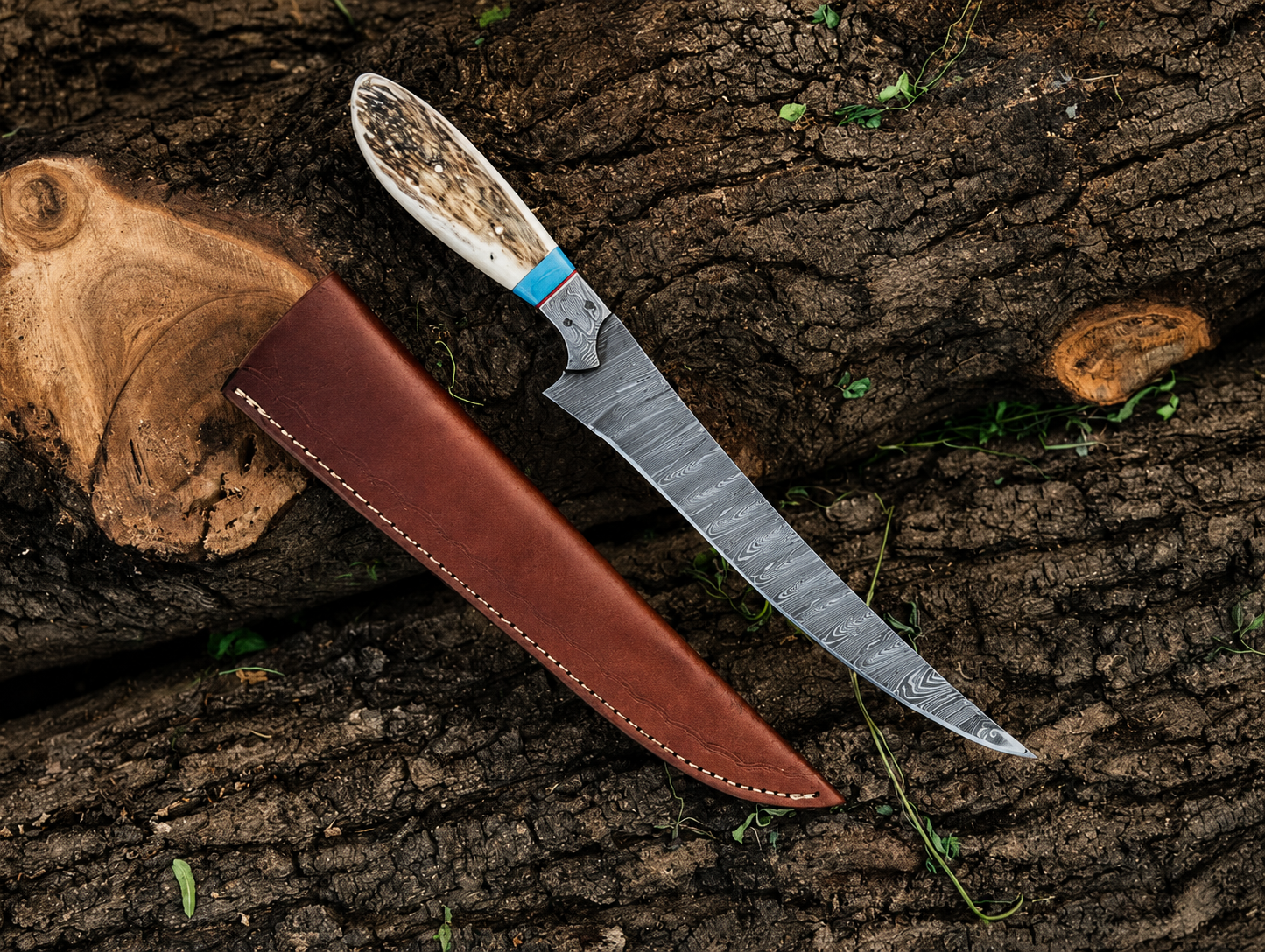 A fixed-blade knife with a patterned steel blade, a natural bone handle, and a brown leather sheath, arranged diagonally on a textured tree bark background.