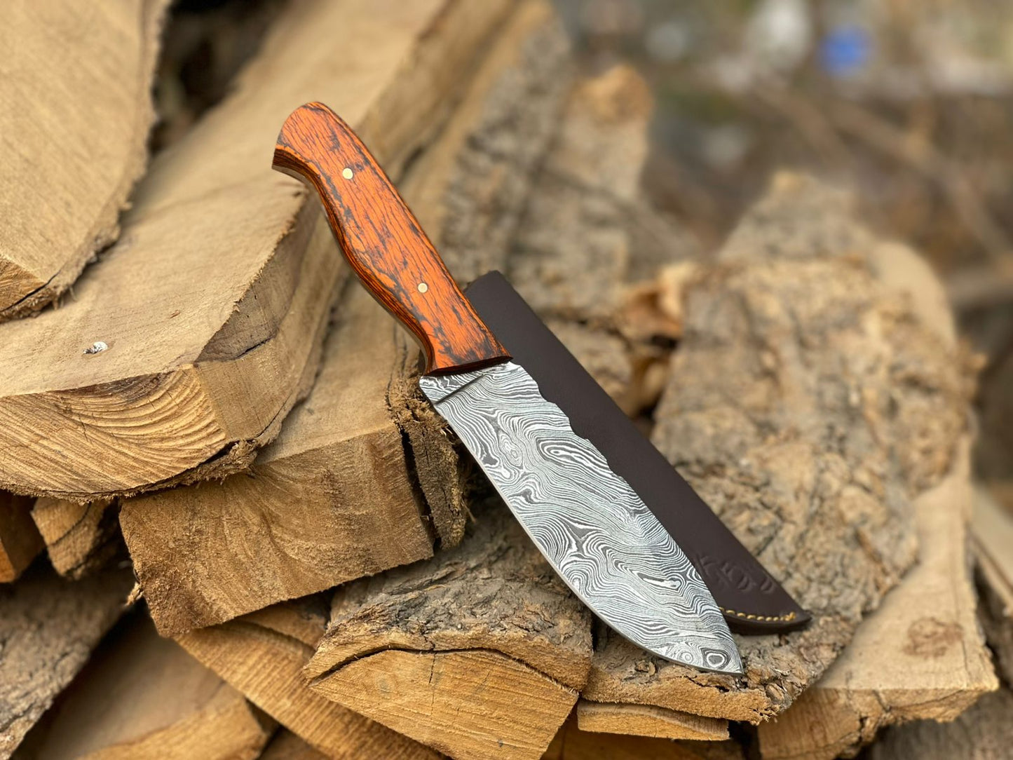 Knife with a wooden handle and decorative blade on stacked wood