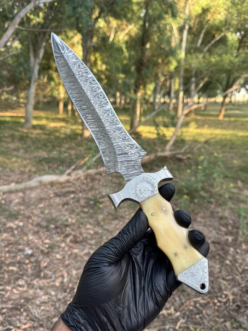 Hand holding a with a detailed blade and wooden handle in a natural setting