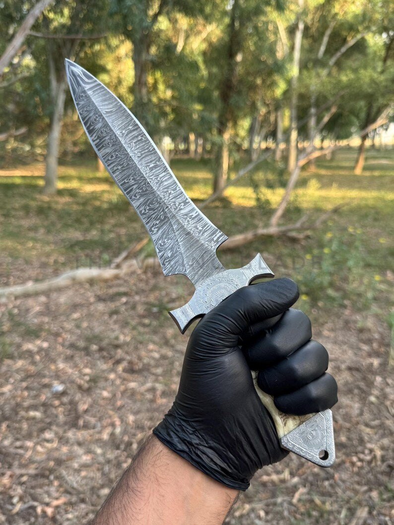 Hand holding a large with a textured blade in a forest setting
