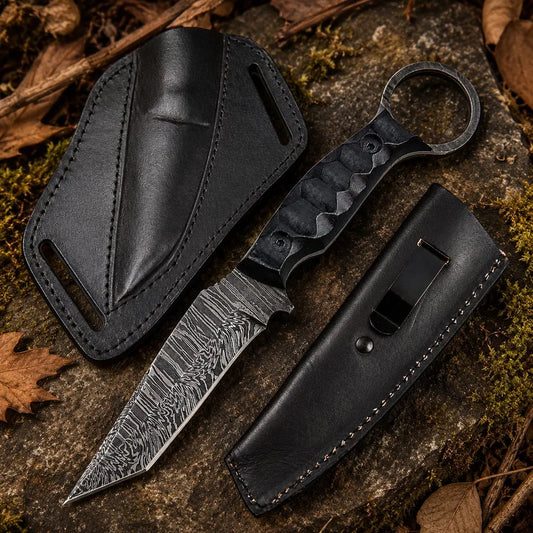 Knife with black leather sheath on a textured surface with leaves