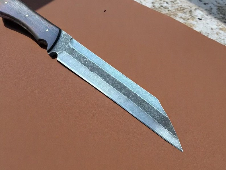 Knife with a wooden handle on a brown surface.
