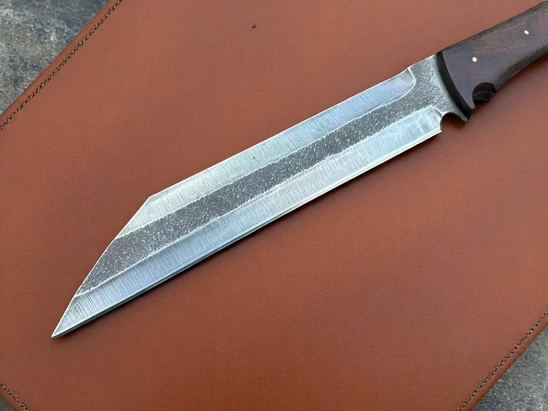 Knife with a textured blade on brown leather background