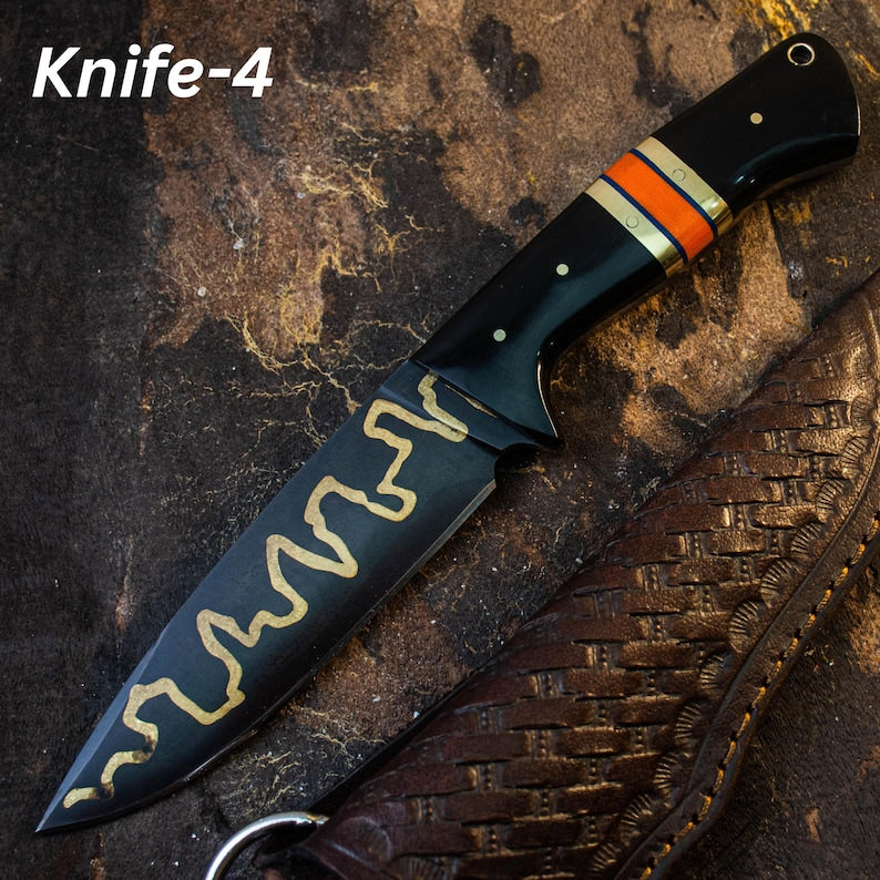 A custom handmade hunting Viking knife with a black and gold patterned blade, and an orange and black handle, positioned on a textured dark background.