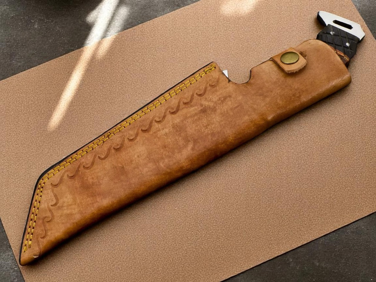 Brown leather knife sheath on a cardboard background