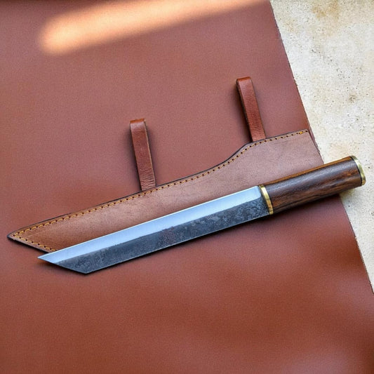 A custom handmade seax knife with a brown wooden handle and a Damascus patterned blade, accompanied by a brown leather sheath.