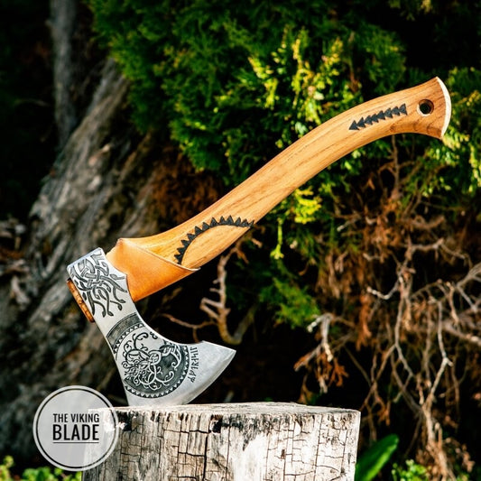 A handmade Viking axe with a steel head featuring a Tree of Life motif, and a wooden handle with a leather sheath attached.