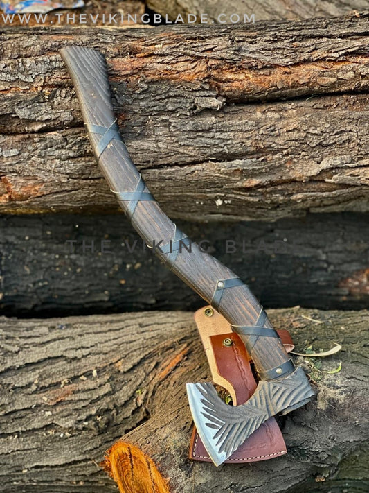 Viking-style axe with leather sheath on wooden background