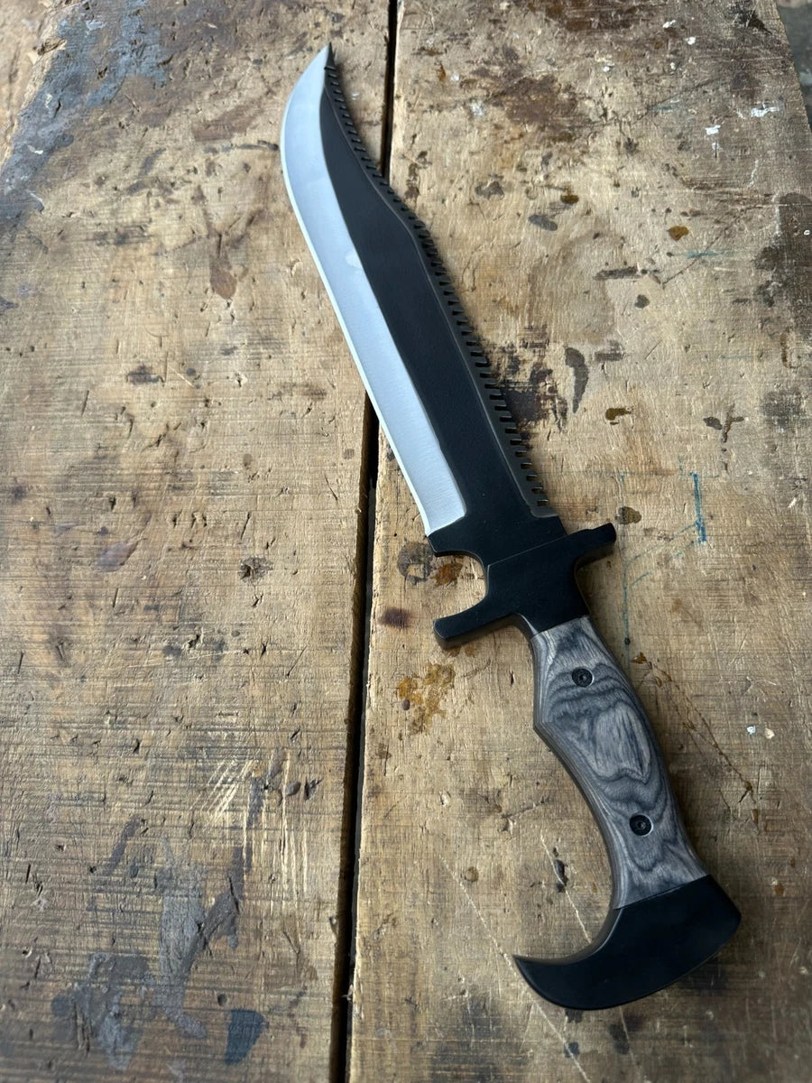 A fixed-blade knife with a black-coated blade, a black bolster, and a gray marbled wood handle, displayed diagonally on a rustic wooden plank surface.