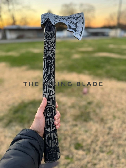 Decorative axe held by a person with 'The Viking Blade' branding, outdoors.