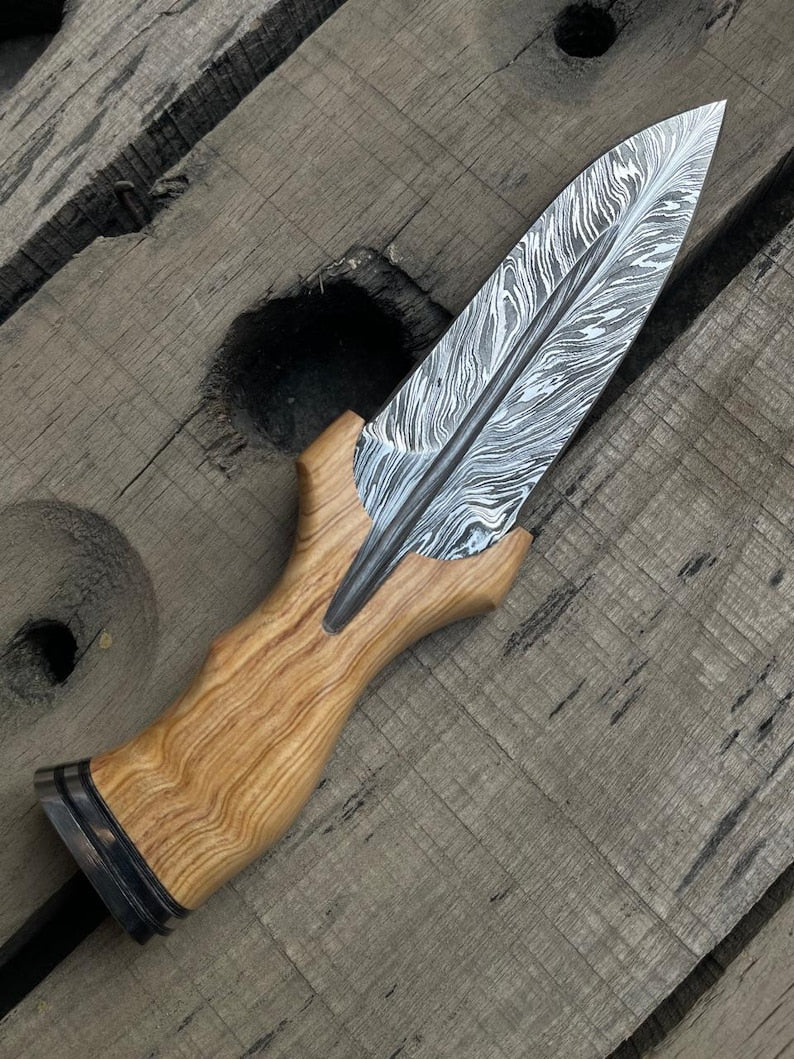 Decorative knife with a wooden handle on a wooden surface