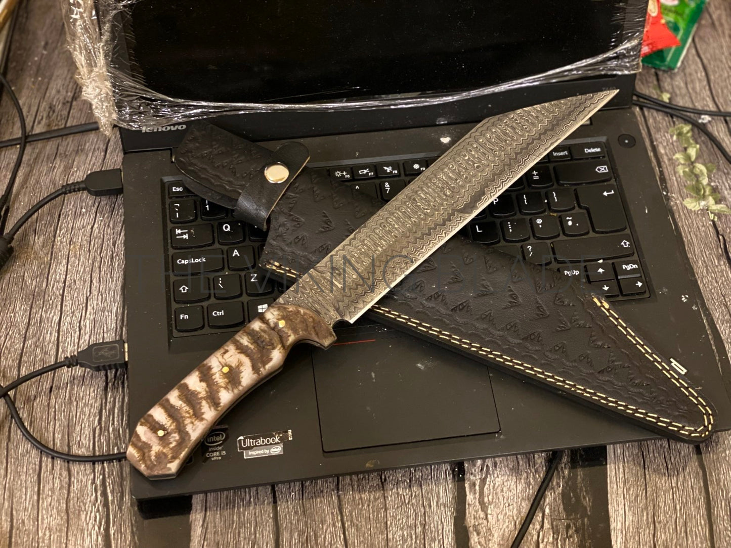 Large knife with a camouflage handle on a laptop