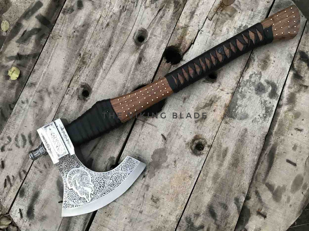 Decorative axe with a wooden handle on a rustic wooden surface