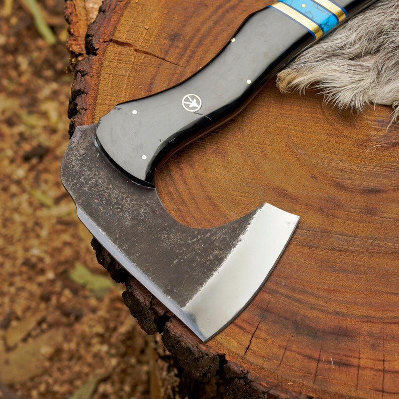 Ax with a blue handle on a wooden surface