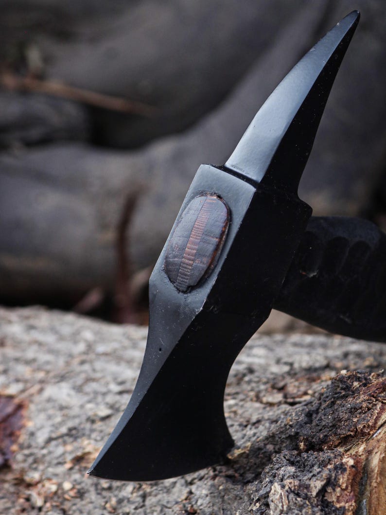 Black knife with wooden handle on a rocky surface
