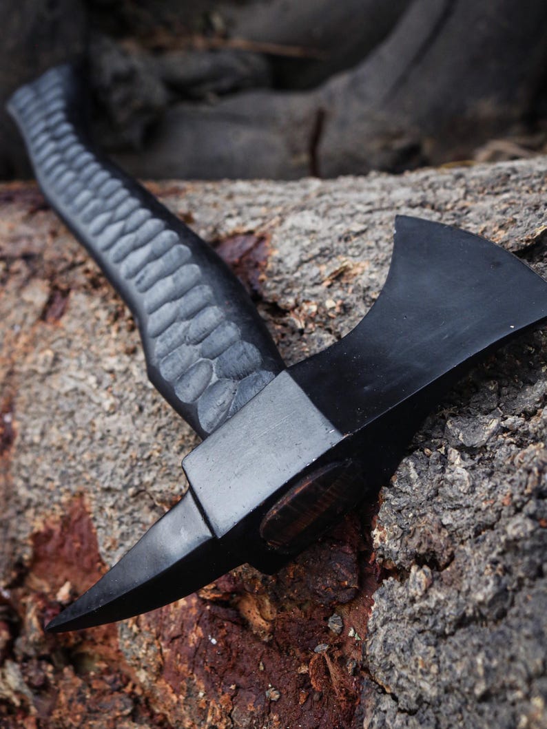 Black axe with a textured handle on a wooden surface