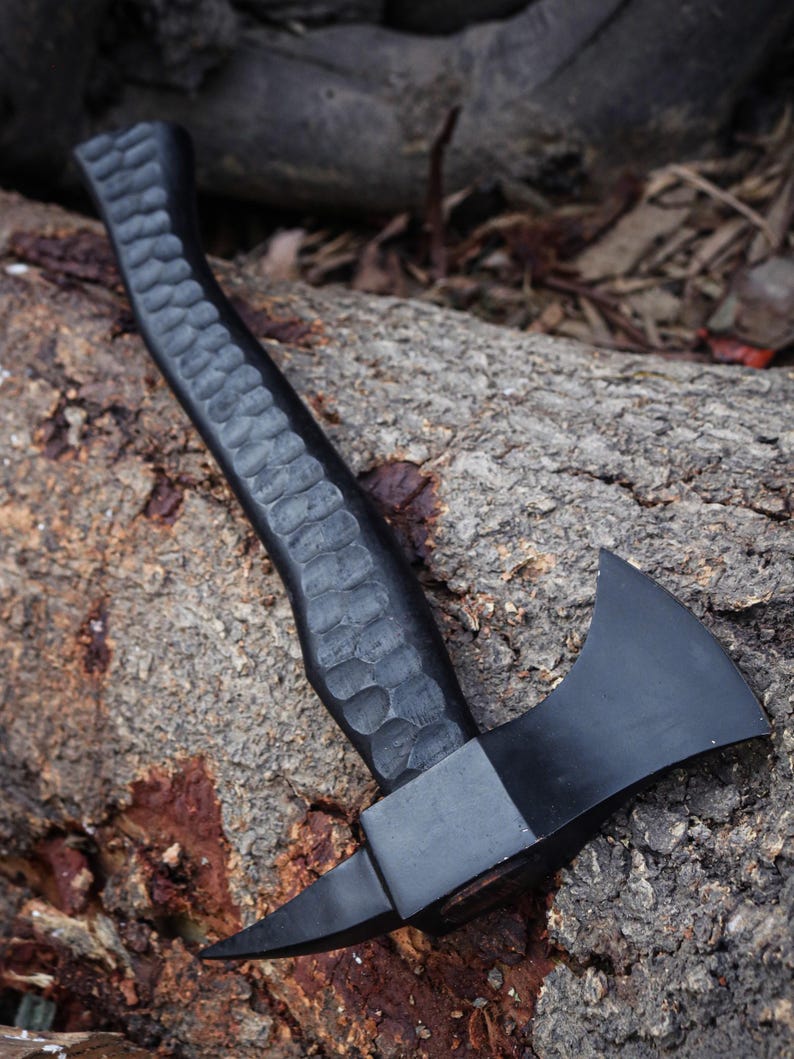 Black axe with textured handle on a stone surface