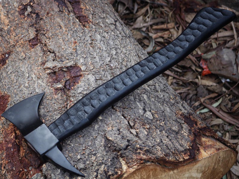 Black axe with textured handle on a wooden surface