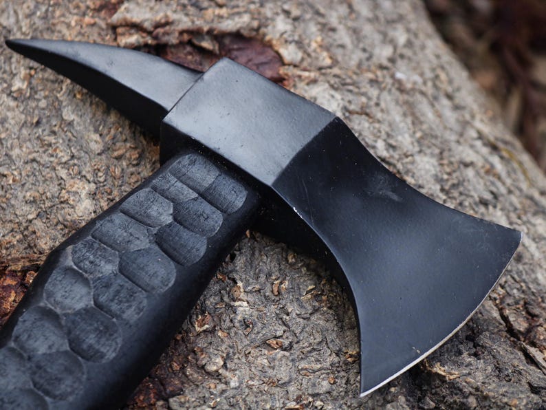 Black axe with a textured handle on a wooden surface