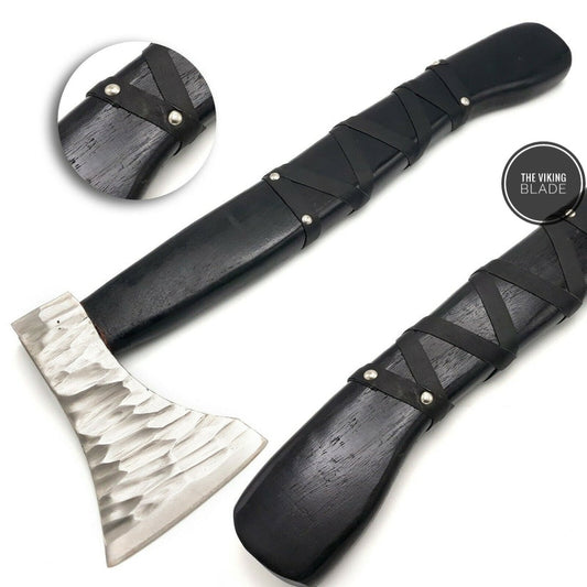 A hand forged carbon steel Viking axe with a rose wood handle and a leather sheath. The axe has a patterned blade and a black leather handle with a braided strap.