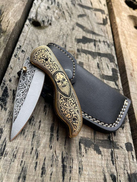 Decorative pocket knife with skull design on a wooden surface