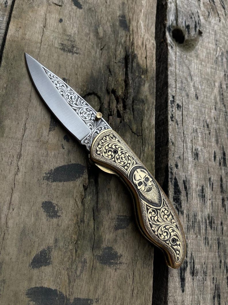 Decorative pocket knife with skull design on a wooden surface