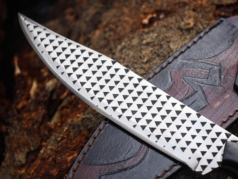 Decorative knife blade with geometric pattern on a wooden background