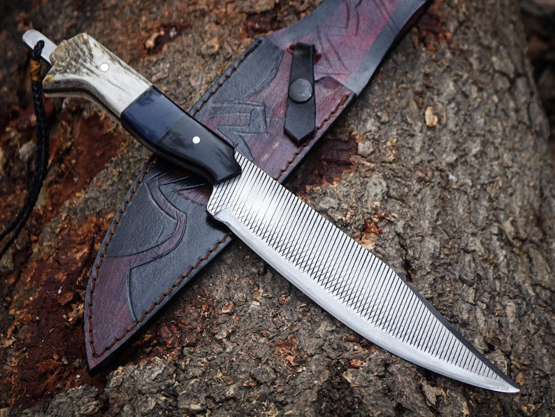 Forked knife with a leather sheath on a textured surface
