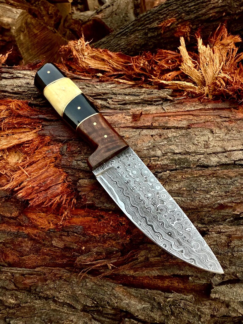 Decorative knife with a wooden handle on a wooden background