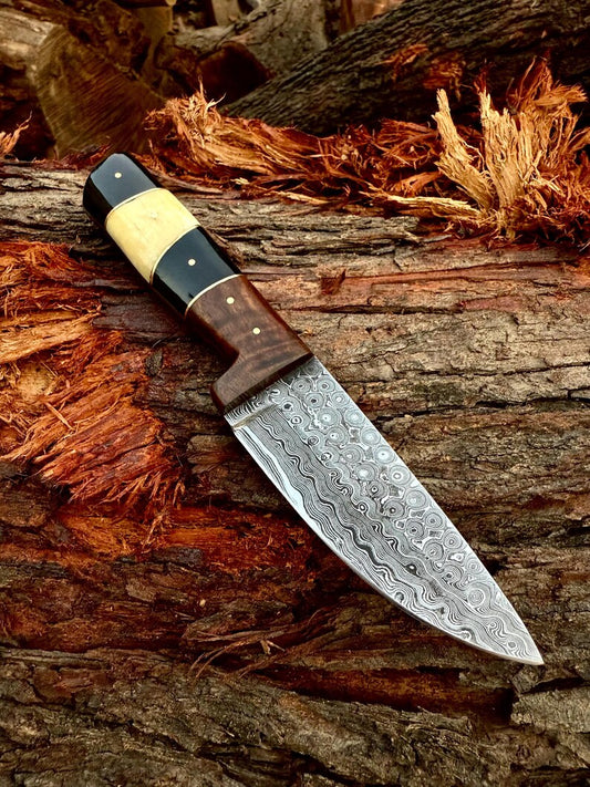 Decorative knife with a wooden handle on a wooden background