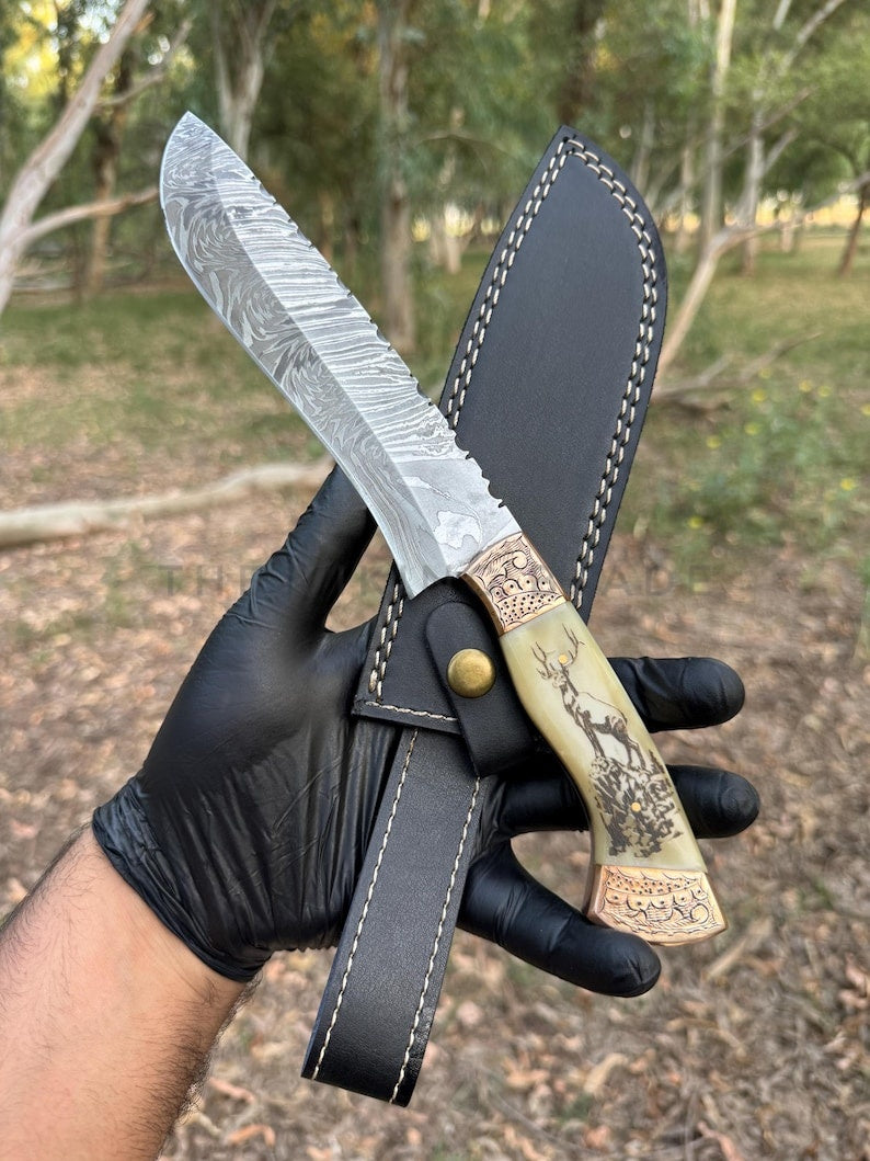 Knife with decorative handle held by a gloved hand against a natural background