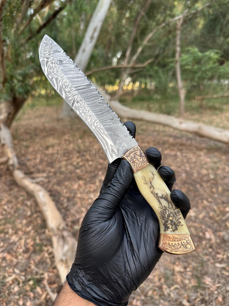 Hand holding a decorative knife with a black glove against a natural background