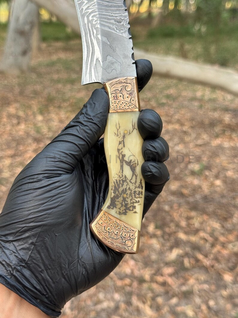 Hand holding a decorative knife with a detailed handle, blurred natural background