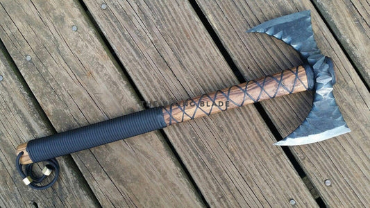 Axes with leather-wrapped handles on a wooden surface